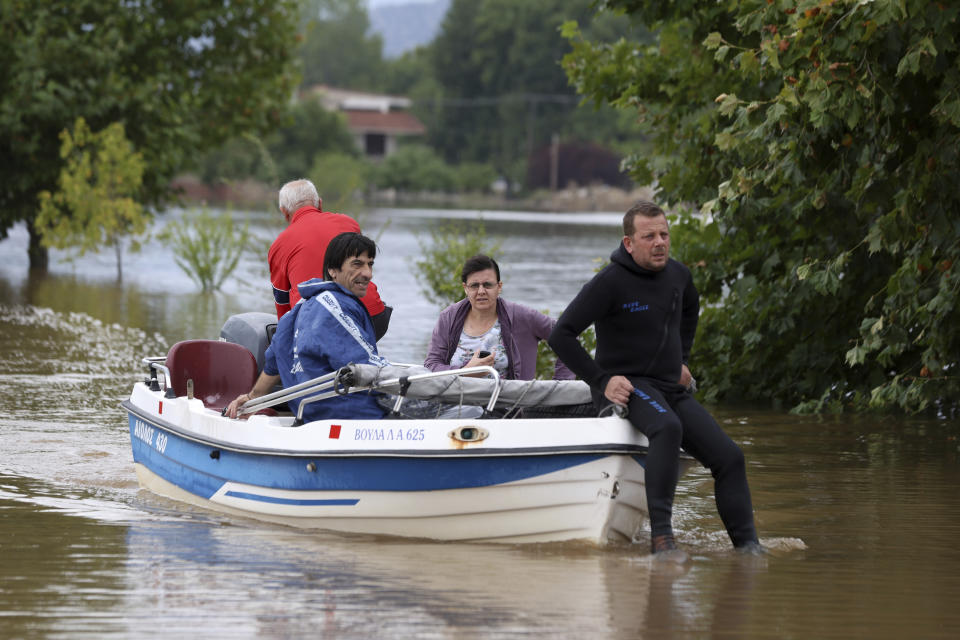 Local residents use a small boat during an evacuee operation from the village of Farkadona, Thessaly region, central Greece, Thursday, Sept. 7, 2023. Greece's fire department says more than 800 people have been rescued over the past two days from floodwaters, after severe rainstorms turned streets into raging torrents, hurling cars into the sea and washing away roads. (AP Photo/Vaggelis Kousioras)