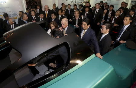 California Governor Jerry Brown (C) and Japanese Prime Minister Shinzo Abe get a demonstration of the JR-East Shinkansen train simulator at the Fairmont Hotel in San Francisco, California in this April 30, 2015 file photo. REUTERS/Jeff Chiu/Pool