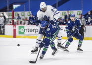 Toronto Maple Leafs' Wayne Simmonds (24) checks Vancouver Canucks' Quinn Hughes (43) during the third period of an NHL hockey game in Vancouver, British Columbia, Sunday, April 18, 2021. (Darryl Dyck/The Canadian Press via AP)