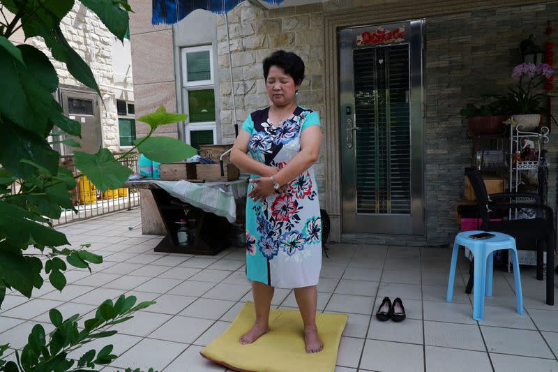 Yang Xiaolan practises Falun Gong at her backyard during an interview in Hong Kong