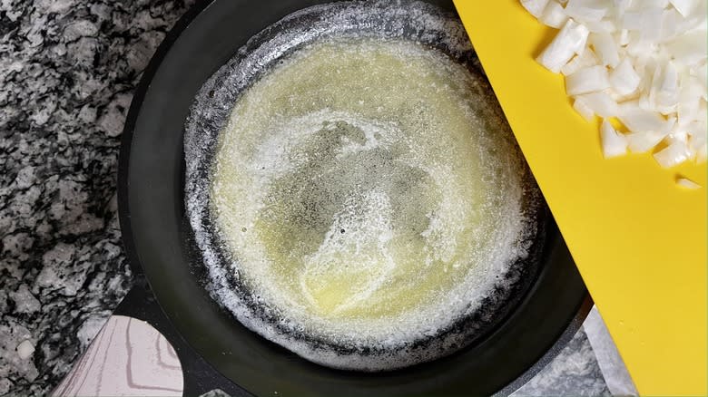melted butter in skillet next to diced onions
