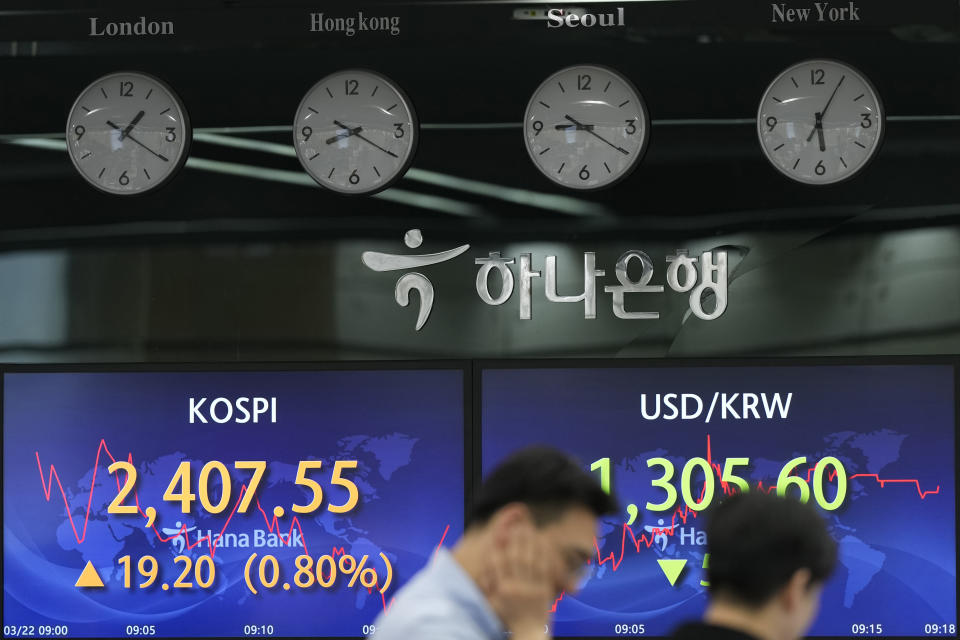 Currency traders talk near the screens showing the Korea Composite Stock Price Index (KOSPI), left, and the foreign exchange rate between U.S. dollar and South Korean won at a foreign exchange dealing room in Seoul, South Korea, Wednesday, March 22, 2023. Asian shares advanced Wednesday after a Wall Street rally led by the banks most beaten down by the industry’s crisis.(AP Photo/Lee Jin-man)