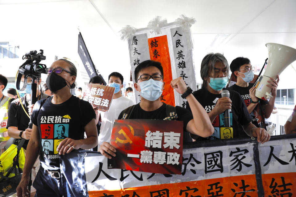 Pro-democracy protesters shout slogans " Stop One Party Rolling" as they march toward the flag raising ceremony, in Hong Kong, Wednesday, July 1, 2020. Hong Kong marked the 23rd anniversary of its handover to China in 1997, one day after China enacted a national security law that cracks down on protests in the territory. (AP Photo/Vincent Yu)