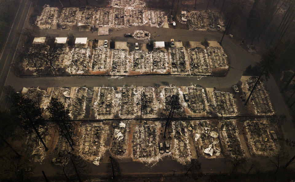 FILE - This Nov. 15, 2018, aerial file photo shows the remains of residences leveled by the Camp wildfire in Paradise, Calif. Pacific Gas & Electric Corp.'s top financial executives say they still haven't determined when the utility can start compensating victims of recent wildfires started by the utility's equipment. (AP Photo/Noah Berger, File)