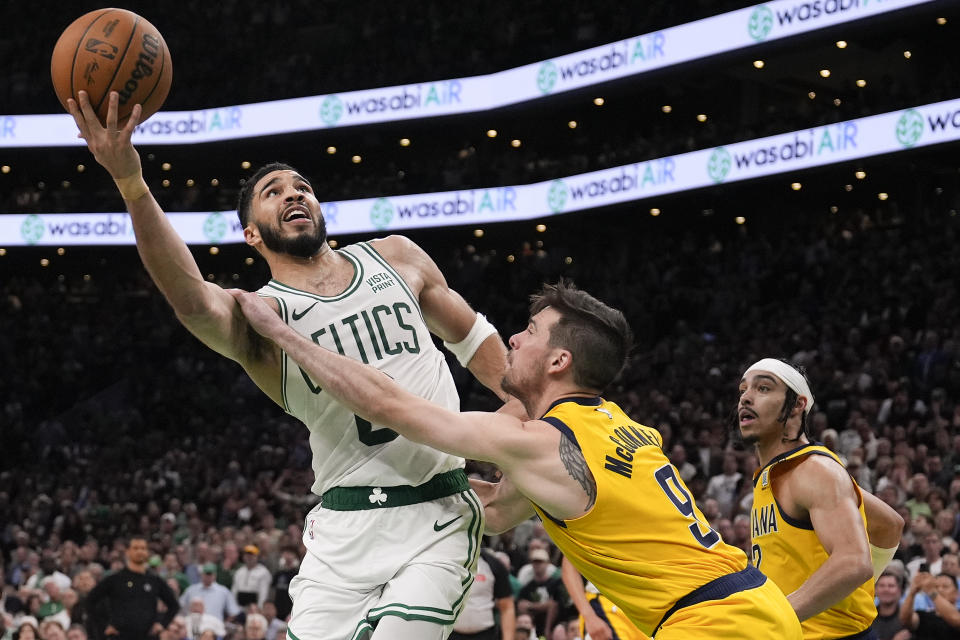 Boston Celtics forward Jayson Tatum (0) shoots over Indiana Pacers guard TJ McConnell (9) during overtime in Game 1 of the NBA Eastern Conference basketball finals in Boston, Tuesday, May 21, 2024. (AP Photo/Charles Krupa)