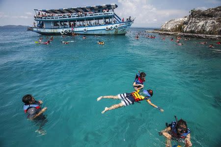 Tourists swim in clear water near Kut island, eastern Thailand, in this April 24, 2014 file photo. REUTERS/Athit Perawongmetha