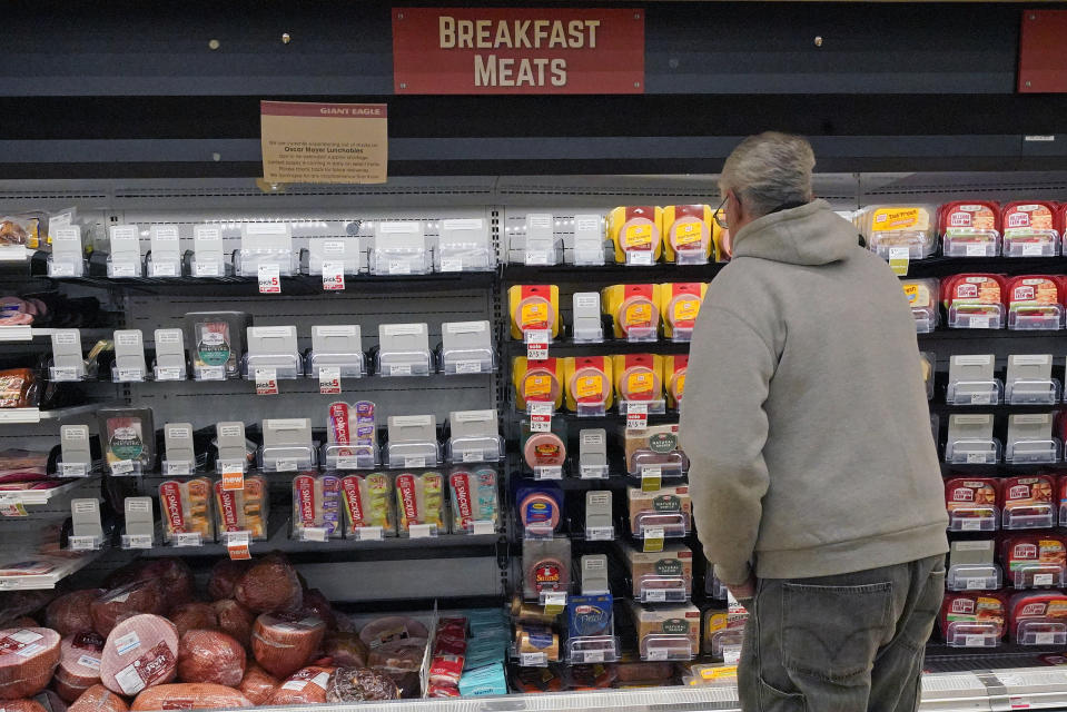 A shopper at a grocery in Pittsburgh looks at the partially empty display of breakfast meats on Tuesday, Jan. 11, 2022. Shortages at U.S. grocery stores have grown in recent weeks as new problems — like the fast-spreading omicron variant and severe weather — have piled on to the supply chain struggles and labor shortages that have plagued retailers since the coronavirus pandemic began. (AP Photo/Gene J. Puskar)