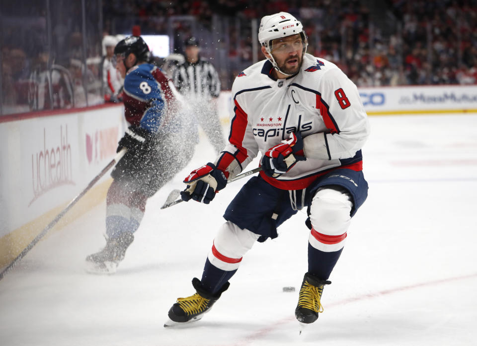 Washington Capitals left wing Alex Ovechkin, front, fights for control of the puck with Colorado Avalanche defenseman Cale Makar in the first period of an NHL hockey game Thursday, Feb. 13, 2020, in Denver. (AP Photo/David Zalubowski)