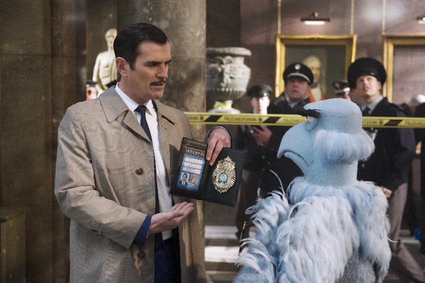 This image released by Disney shows the muppet character Sam the Eagle, right, with Ty Burrell in a scene from "Muppets Most Wanted." (AP Photo/Disney Enterprises, Inc.)