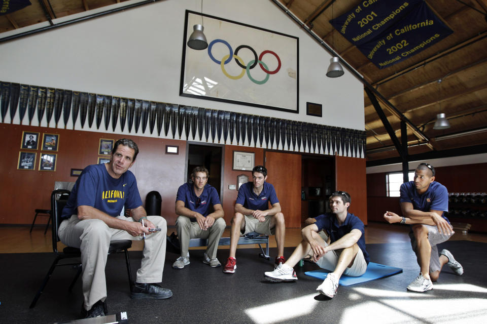 FILE - In this May 7, 2012, file photo, coach Mike Teti, left, talks to his United States eight man crew team during practice in Oakland, Calif. As the Tokyo Games approach, US Rowing is awaiting the results of a months-long assessment commissioned by the U.S. Olympic & Paralympic Committee of its national team programs, including the men's group based in Oakland, where longtime coach Mike Teti is being criticized by some rowers for what they call his intense and intimidating style. (AP Photo/Paul Sakuma, File)