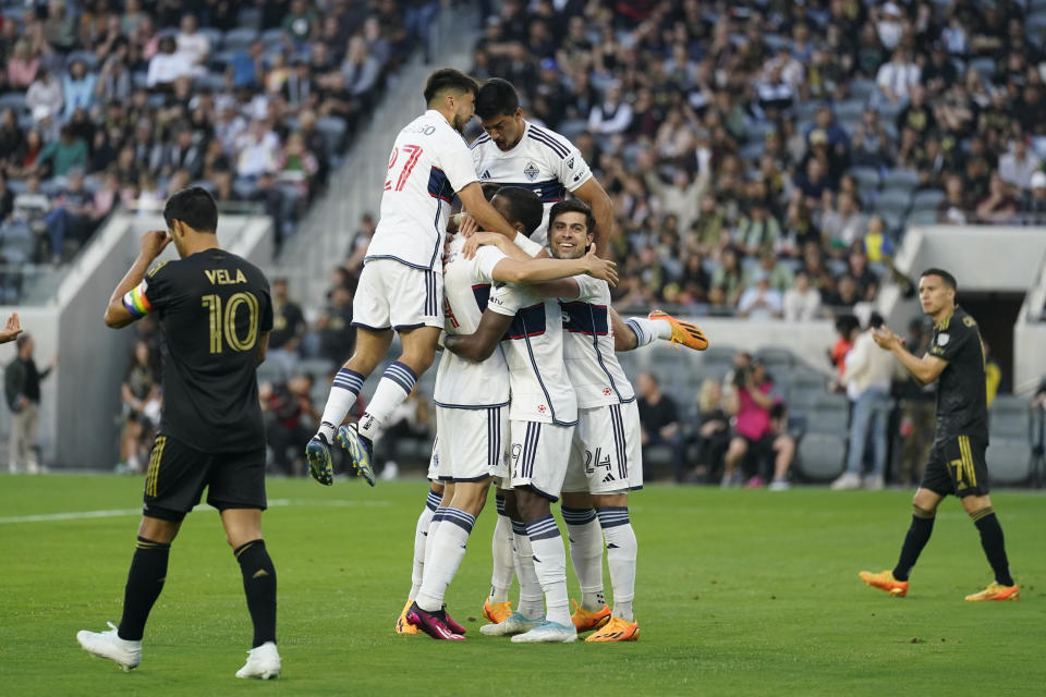 Vancouver Whitecaps players celebrate after defender Ranko Veselinović (4) scored during the first half of an MLS soccer match against Los Angeles FC in Los Angeles, Saturday, June 24, 2023. (AP Photo/Ashley Landis)