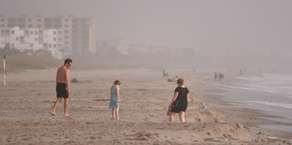 Condos disappear in the distance for beachgoers walking the beach in Cocoa Beach Tuesday. Smoke from the Canadian wildfires has blanketed Florida with haze and air quality alerts have been issued for people with health issues.