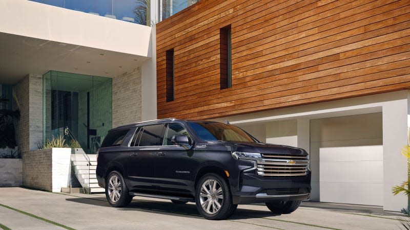 A photo of a black Chevrolet Suburban SUV parked outside a house. 