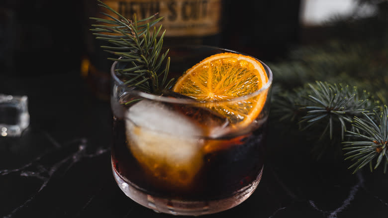 cocktail with orange slice and pine