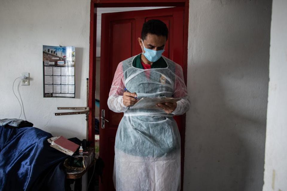 Relatives of a man who died at home are asked routine questions by a professional from the municipal health secretariat in Manaus on 15 January.