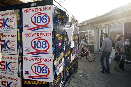 Kosovar Serbs walk past election campaign posters of Savez Kosovski Srba (L) (Alliance of Kosovo Serbs) and Samostalna Liberalna Stranka (Independent Liberal Party) in the town of Gracanica, which is largely inhabited by Serbians, November 2, 2013. REUTERS/Hazir Reka