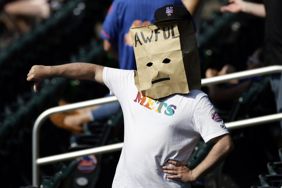 A New York Mets fan reacts during the ninth inning against the Atlanta Braves in the first baseball game of a doubleheader on Saturday, Aug. 12, 2023, in New York. The Braves won 21-3. (AP Photo/Adam Hunger)