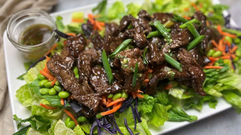 salad with mongolian beef on white platter