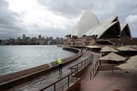 A worker cleans the waterfront area of the Sydney Opera House