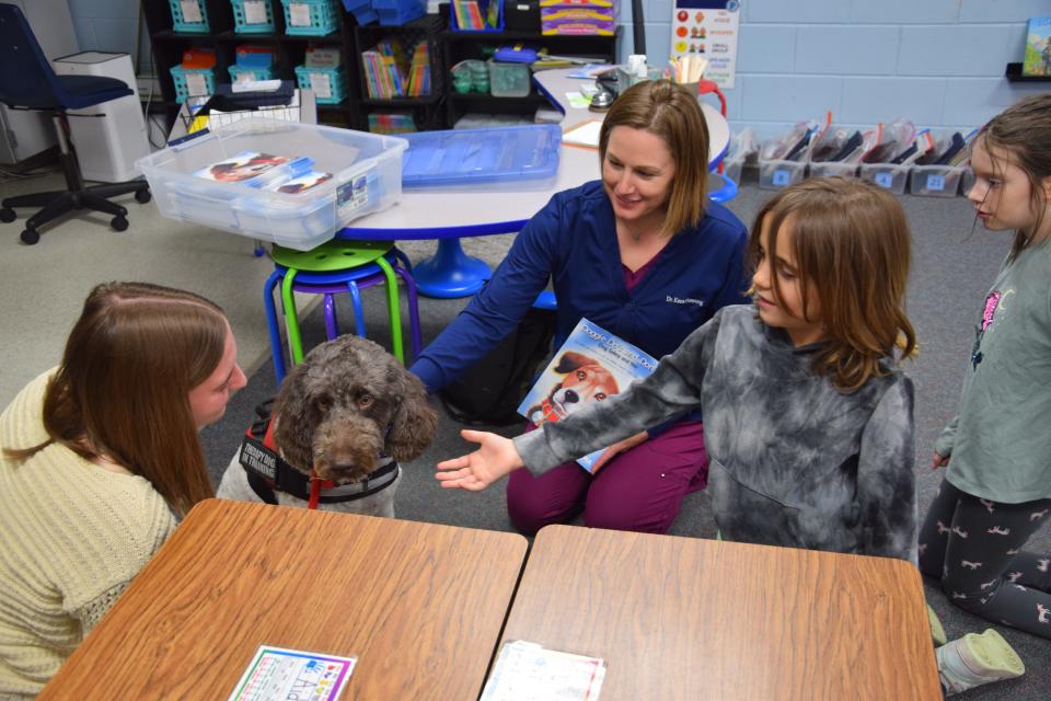 Julian Harrold-Kaszubowski introduces himself to Henry, the therapy dog at Lincoln Elementary School.
