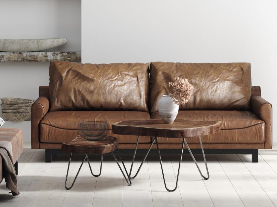 Chocolate-brown couch with table in front of it and a shelf behind the couch