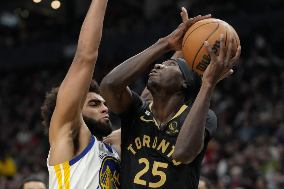 Toronto Raptors forward Chris Boucher (25) looks for an angle as Golden State Warriors forward Anthony Lamb (40) defends during the first half of an NBA basketball game in Toronto, Sunday, Dec. 18, 2022. (Frank Gunn/The Canadian Press via AP)