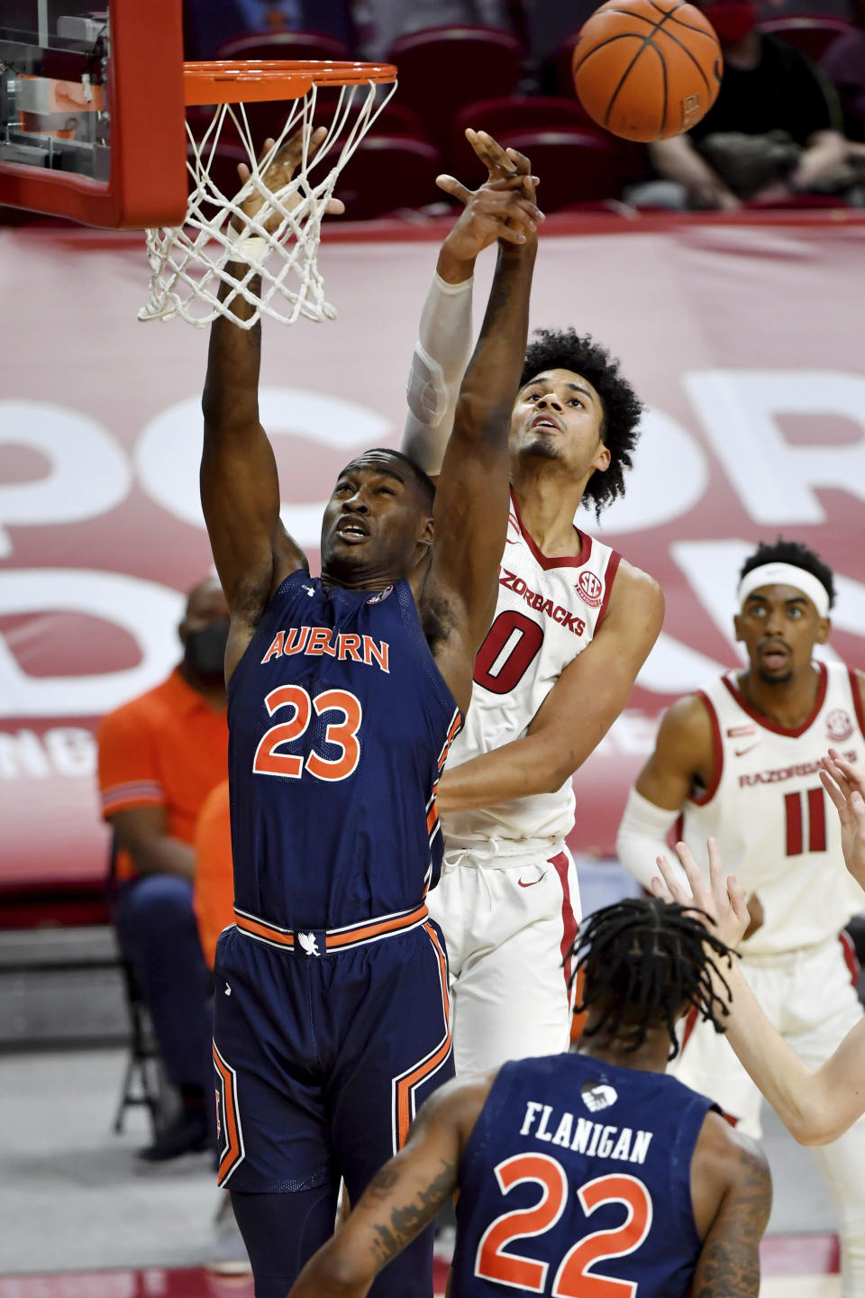 Arkansas forward Justin Smith (0) and Auburn forward Jaylin Williams (23) reach for a rebound during the first half of an NCAA college basketball game Wednesday, Jan. 20, 2021, in Fayetteville, Ark. (AP Photo/Michael Woods)