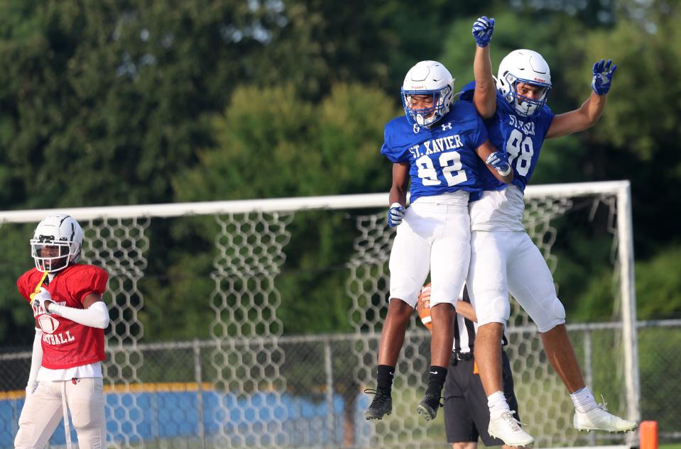 St. Xavier tight end Joey Wassler (88) and wide receiver Jamaal Sharp (82) celebrate after a touchdown during their scrimmage against Colerain Friday, Aug 12, 2022.