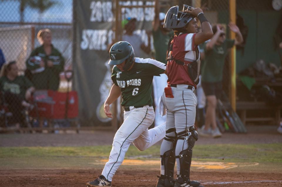 Jupiter second baseman Mason Barela (6) crosses home plate at the bottom of the second inning as Palm Beach Central catcher David Urrutia (13) looks for the ball during the District 11-7A championship baseball game between host Jupiter and Palm Beach Central on Thursday, May 4, 2023, in Jupiter, Fla. Final score, Jupiter, 11, Palm Beach Central, 3.