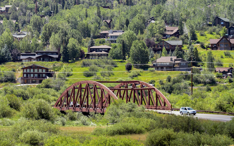 A motorist passes through a hillside community, Thursday, Aug. 4, 2022, in Steamboat Springs, Colo. The city council passed a rule in June that could prove to be a model for other vacation towns: A ban on new short-term rentals in most of the city and a ballot measure to tax bookings at 9% to fund affordable housing. (AP Photo/Thomas Peipert)