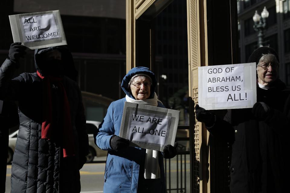 Demonstrators stand with signs during an interfaith solidarity protest against President Donald Trump's executive immigration ban outside the Downtown Islamic Center on February 3, 2017 in Chicago, Illinois.