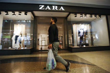 A man walks past a Zara retail store, with its shutters drawn, at a mall in Caracas September 30, 2014. REUTERS/Carlos Garcia Rawlins
