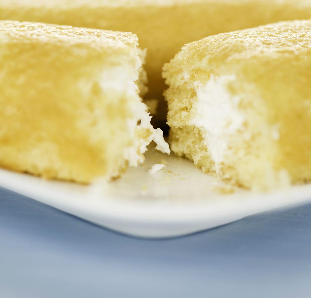 Suffolk, Virginia, USA - September 28, 2013: A square format studio shot of two Hostess Twinkies cakes with the front one broken open showing creamy filling.