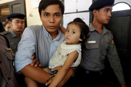 Detained Reuters journalist Kyaw Soe Oo, handcuffed, carries his daughter Moe Thin Wai Zin while arriving at a court hearing in Yangon, Myanmar May 16, 2018. REUTERS/Ann Wang