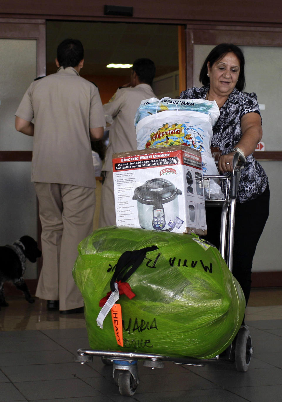 Maria Roque, who lives in Cuba, arrives with her luggage from the U.S. at the Jose Marti International Airport in Havana, Cuba, Monday, Sept. 3, 2012. A steep hike in customs duties has taken effect in Cuba, catching some air travelers unaware and leaving others irate at the new fees. (AP Photo/Franklin Reyes)