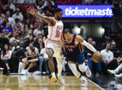 New York Knicks guard Jalen Brunson (11) dribbles the ball while being guarded by Miami Heat forward Haywood Highsmith (24) during the first half of an NBA basketball game, Wednesday, March 22, 2023, in Miami, Fla. (AP Photo/Michael Laughlin)