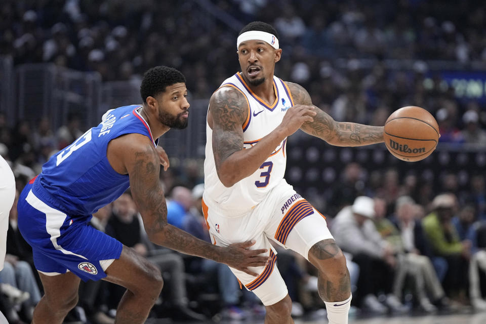 Phoenix Suns guard Bradley Beal, right, drives past Los Angeles Clippers forward Paul George during the first half of an NBA basketball game Monday, Jan. 8, 2024, in Los Angeles. (AP Photo/Mark J. Terrill)