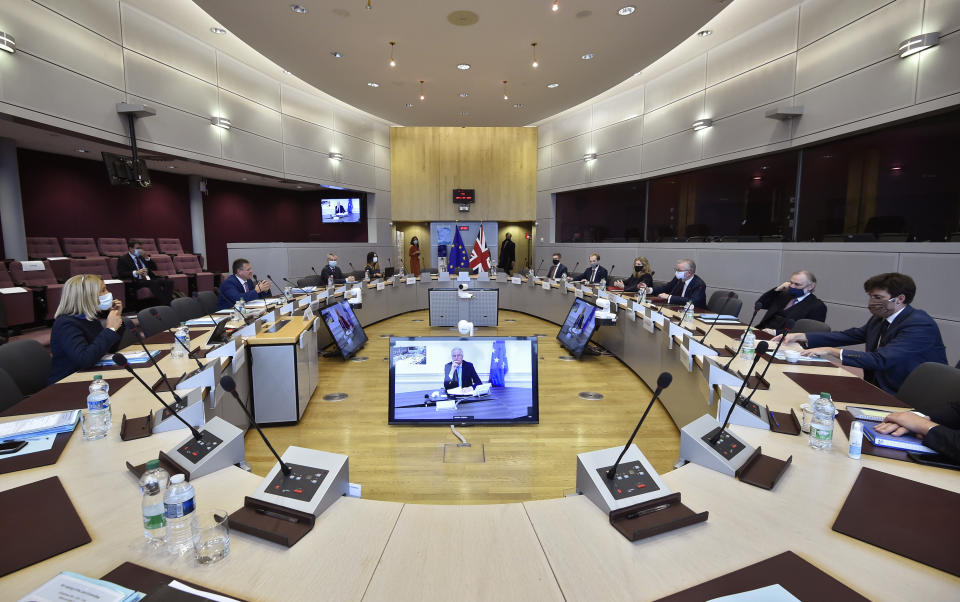 Chancellor of the Duchy of Lancaster Michael Gove, center right, and Vice-President of the European Commission in charge of Inter-institutional relations and Foresight Maros Sefcovic, center left, attend the third meeting of the EU-UK Joint Committee at EU headquarters in Brussels, Monday, Sept. 28, 2020. At center on screen is EU chief Brexit negotiator Michel Barnier joining by videoconference. (John Thys, Pool via AP)