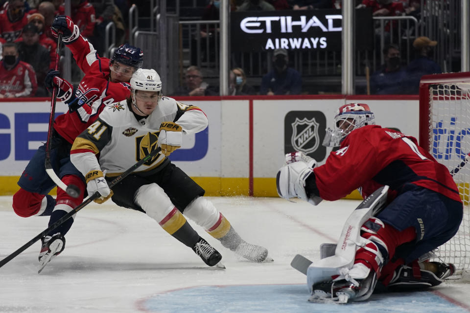 Washington Capitals goaltender Vitek Vanecek, right, watches as Vegas Golden Knights center Nolan Patrick (41) is defended by Capitals defenseman Martin Fehervary, left, during the first period of an NHL hockey game, Monday, Jan. 24, 2022, in Washington. (AP Photo/Evan Vucci)