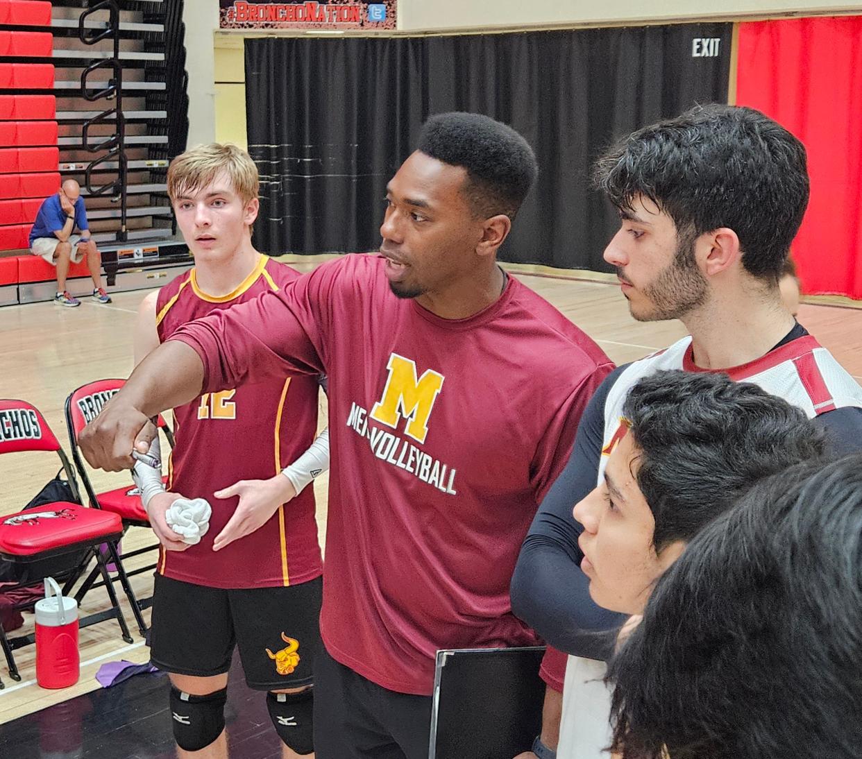 McCutcheon coach Keith Crisler talks to his team during a timeout with sophomore libero Korbin Vannette (12) and senior outside hitter Corrado Franza looking on during the IBVCA quarterfinal against Kokomo on Tuesday, May 7, 2024 in Lafayette, Ind.