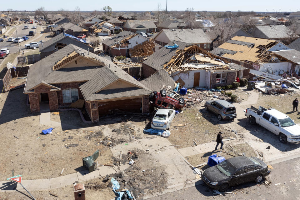 Residents assess damage along Conway Drive in Norman, Okla., Monday, Feb. 27, 2023, after severe storms and tornadoes moved through the state overnight. (AP Photo/Alonzo Adams)