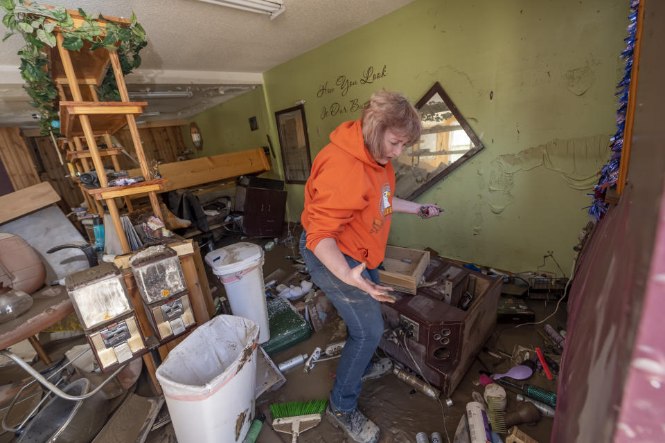 Connie Methner, owner of CJ's Hairstyling, wades through the mud covering the inside of her salon in Sanford, Michigan, on May 21, 2020.  (Photo: David Guralnick/Detroit News via AP)