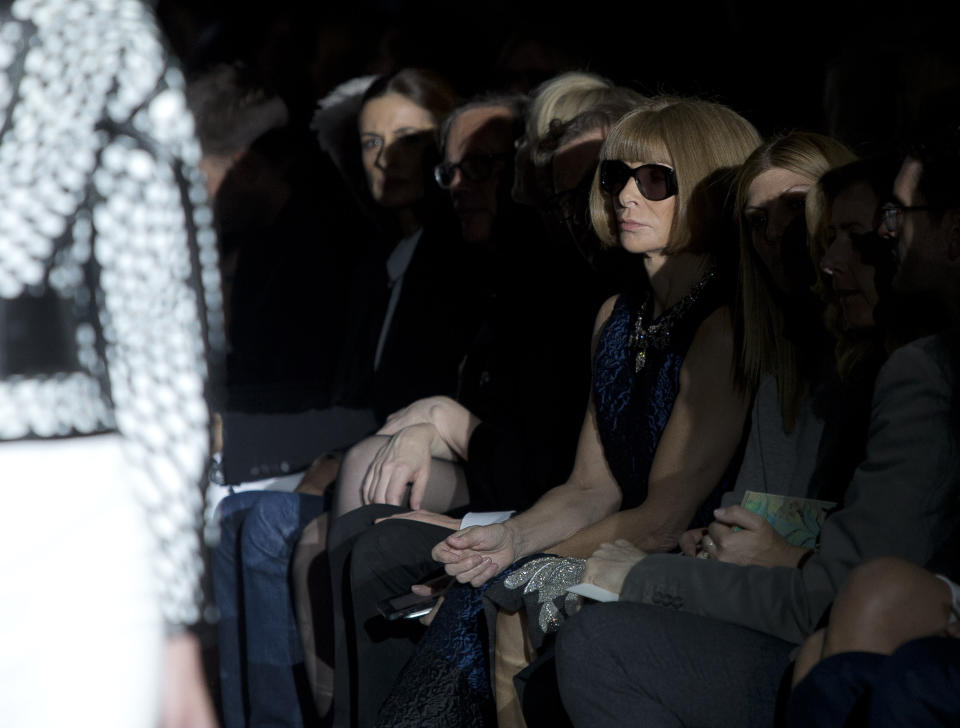 Anna Wintour, centre, watches a model wearing a design created by Tom Ford during London Fashion Week Spring/Summer 2014, at Lindley Hall, central London, Monday, Sept. 16, 2013. (Photo by Joel Ryan/Invision/AP)