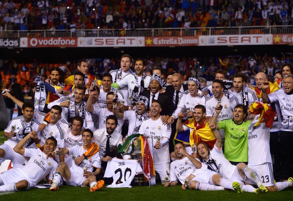 Real Madrid players celebrate with the trophy at the end of the final of the Copa del Rey between FC Barcelona and Real Madrid at the Mestalla stadium in Valencia, Spain, Wednesday, April 16, 2014. Real defeated Barcelona 2-1. (AP Photo/Manu Fernandez)