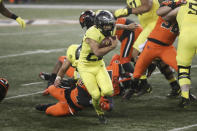 Oregon running back Travis Dye (26) slips a tackle by Oregon State outside linebacker Andrzej Hughes-Murray (49) during the second half of an NCAA college football game in Corvallis, Ore., Friday, Nov. 27, 2020. Oregon State won 41-38. (AP Photo/Amanda Loman)