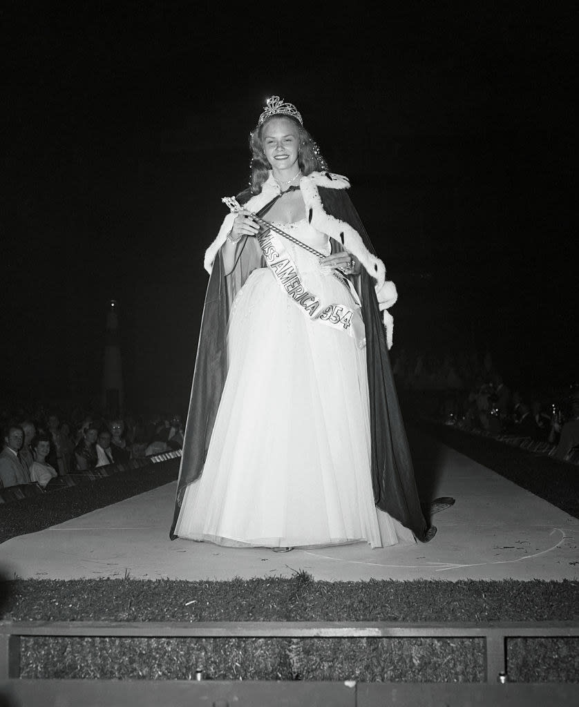 Ay wearing a gown and her crown and robe