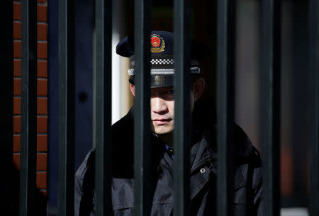 A security guard is pictured through the gate at the kindergarten run by pre-school operator RYB Education Inc being investigated by China's police, in Beijing, China November 24, 2017. REUTERS/Jason Lee