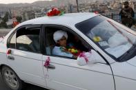 An Afghan teenager sits in a car after celebrating the memorization of the Koran in Kabul