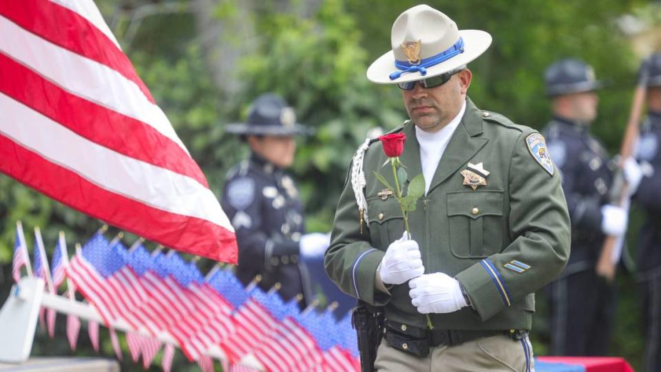 California Highway Patrol officer Joseph Ligon places a rose as names of the 7 California peace officers who died in the line of duty were read. The annual Peace Officer Memorial was hosted by the Arroyo Grande Police Department and held at Heritage Square Park seen here on May 16, 2024.