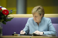 <p>German Chancellor Angela Merkel writes in a book of condolences at the British embassy on May 24, 2017 in Berlin, Germany. (Steffi Loos-Pool/Getty Images) </p>